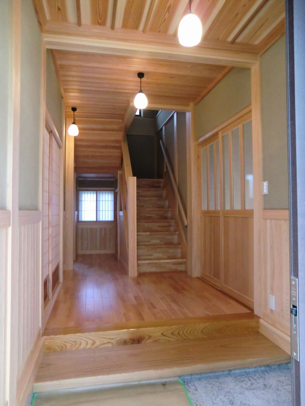 玄関・小縁框タモ、床カバ桜、天井杉板無垢 腰板桧